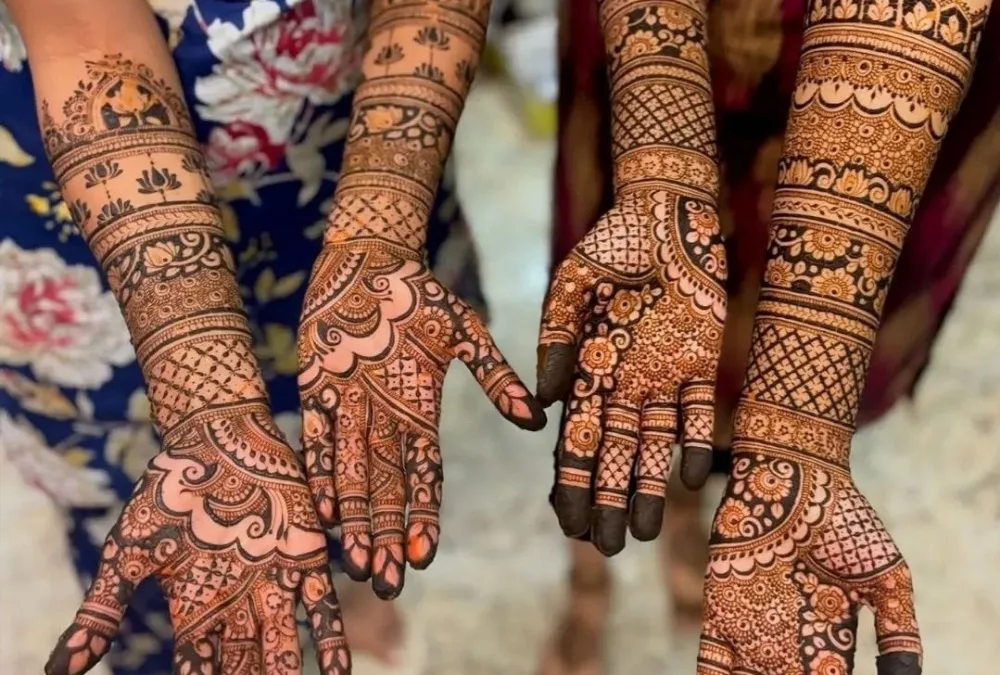 Two clients show their beautiful, full-arm party mehndi designs by Teetu Mehandi Art, the top-rated mehndi artist in Gaur City, Greater Noida.